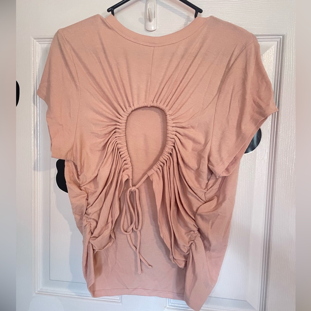 Fitted peach colored shirt with open circle in the back